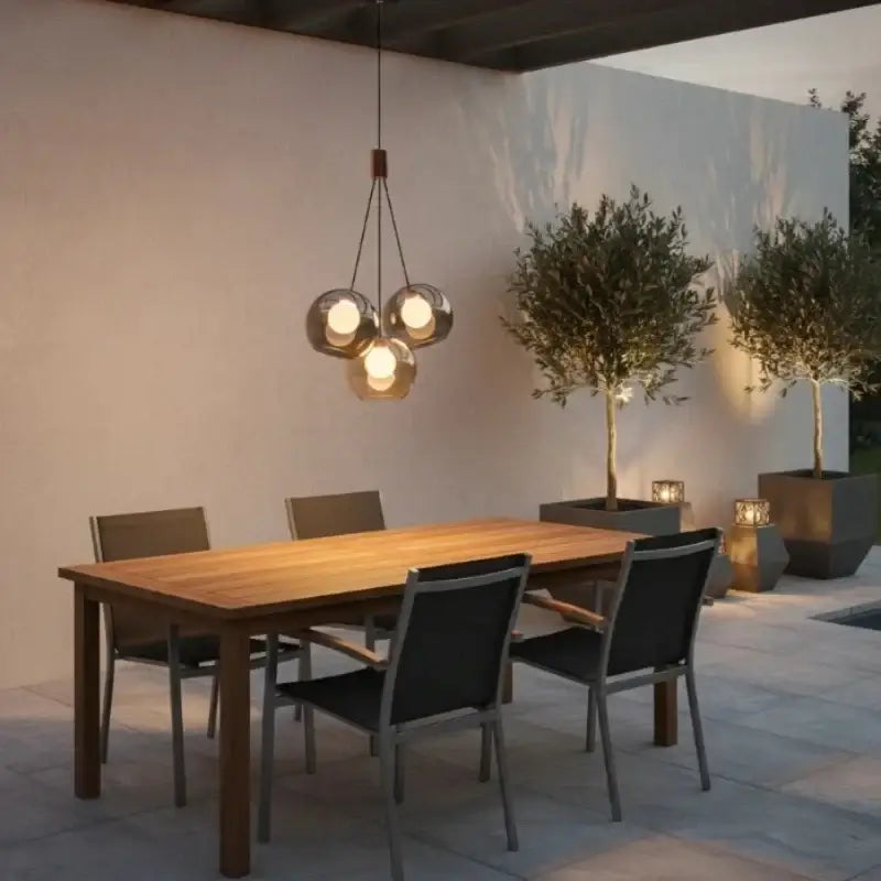 Triple-globe glass pendant light over a wooden dining room table
