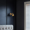 Gold Wall Mounted Spot in Brass and Black Colours illuminating a dark wall, adding a chic and modern touch to the interior.