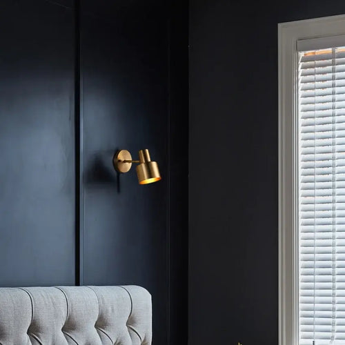 Gold Wall Mounted Spot in Brass and Black Colours illuminating a dark wall, adding a chic and modern touch to the interior.