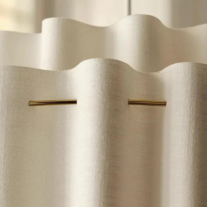 Close-up of a white curtain with a gold rod, showcasing subtle texture and elegant design.