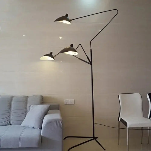 Nordic Designer Tripod Floor Lamp with adjustable arms and sleek design in a modern living room setting.