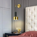 Gold Wall Mounted Spot in Brass and Black Colours lighting elegantly positioned beside a plush bed in a modern bedroom.