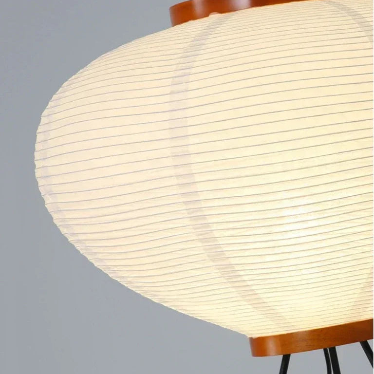 Close-up of a Japanese Rice Paper Lamp with a wooden base and white paper shade on a gray background