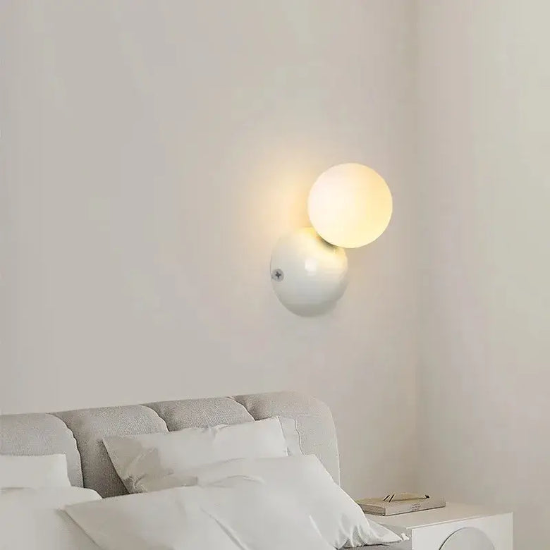 70s revival wall lamp in 3 different colours illuminating a minimalist bedroom interior.