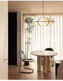 Zen Silk Pendant Light Mid Century Fabric Lantern illuminating a stylish dining area with a modern table and natural lighting.