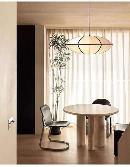 Zen Silk Pendant Light Mid Century Fabric Lantern illuminating a stylish dining area with a modern table and natural lighting.