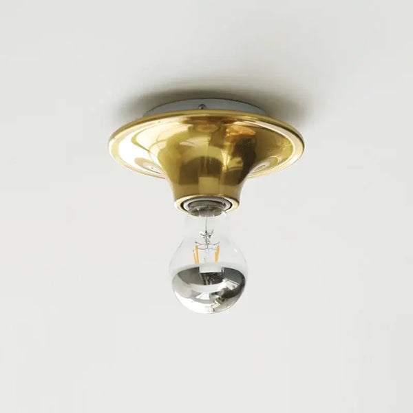 80s revival wall light featuring a gold UFO-shaped base with a silver bulb.