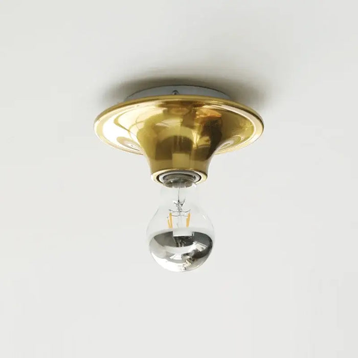 80s revival wall light featuring a gold UFO-shaped base with a silver bulb.