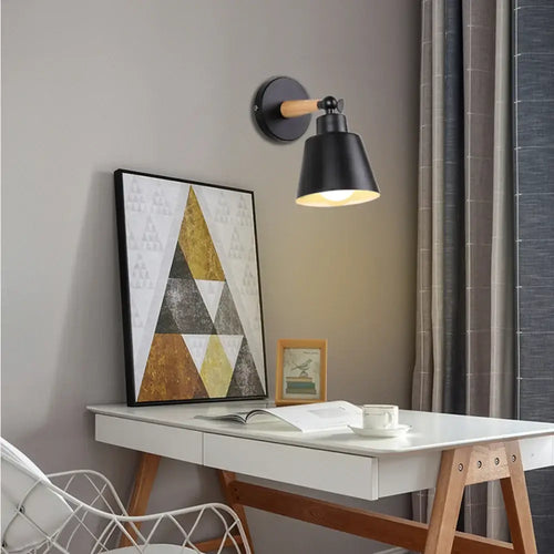 Nordic Solid Wood Bedroom Wall Lamp illuminating a stylish desk with modern decor and a geometric painting.