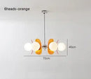 Rare Mid-Century Orange Plexiglass Chandelier: A Unique Vintage Gem showcasing its oval reflectors and frosted glass balls.