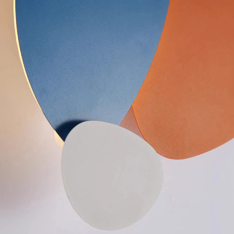 CLose up of the lamp- shapes in blue, orange, and gray on a white background