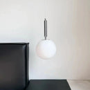 Modern Gold Glass Ball Pendant hanging over a modern black sofa, showcasing sleek design and elegant lighting.