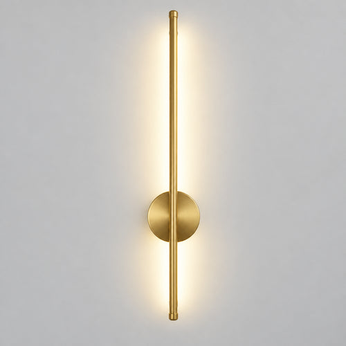 Hero Magnetic Wall Lamp / wall sconce light fixture in brushed gold/brass finish with a circular backplate and vertical light bar, shown lit on a light gray wall.