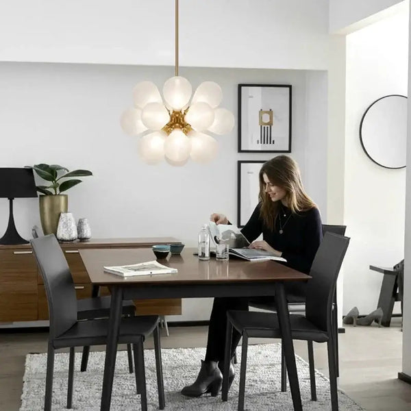 Glorious Tinted Glass Bubble Chandelier illuminating a modern dining space with a woman enjoying a meal.