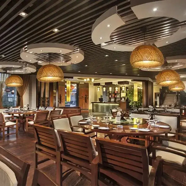 Chic Mid-Century Rattan Chandeliers illuminating a stylish restaurant interior with wooden furniture and modern decor.