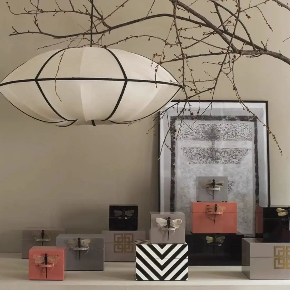 Zen Silk Pendant Light Mid Century Fabric Lantern illuminating a display of decorative boxes.