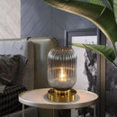 Modern Nordic Glass Table Lighting Fixtures in smoky gray on a side table enhancing a stylish living room decor.
