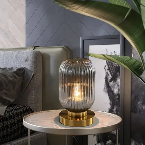 Modern Nordic Glass Table Lighting Fixtures in smoky gray on a side table enhancing a stylish living room decor.
