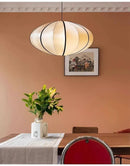 Zen Silk Pendant Light Mid Century Fabric Lantern illuminating a dining room with warm, calming glow.