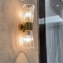 Unique Collection of Art Deco Sconces featuring elegant clear glass and gold accents on a textured wall.