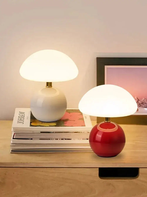 Mushroom LED USB Table Lamp in Pink – Soft Glow Bedside Lighting on a wooden table with decorative books.