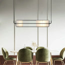White Glass & Metal Art Deco Chandelier hanging over a stylish dining table with green chairs.