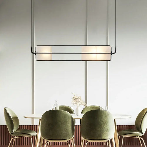 White Glass & Metal Art Deco Chandelier hanging over a stylish dining table with green chairs.