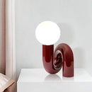 Sculptural Resin Table Lamp – Italian-Inspired Modern Lighting with a bold red design and round frosted glass globe.
