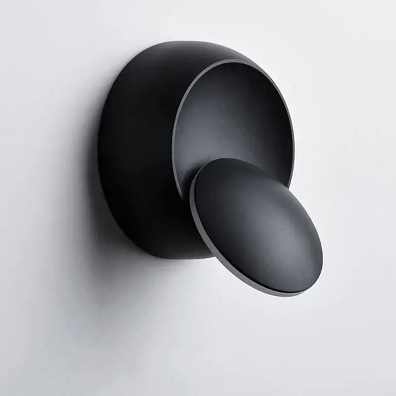 Black wall-mounted round scounce on a light gray background