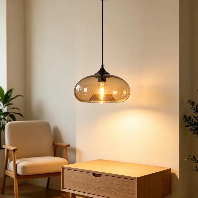 Amber glass dome pendant light hanging beside a wooden sideboard and armchair