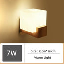 Wood and Frosted Glass Japanese Minimalist Sconces with warm light, featuring a cube design and wooden base.