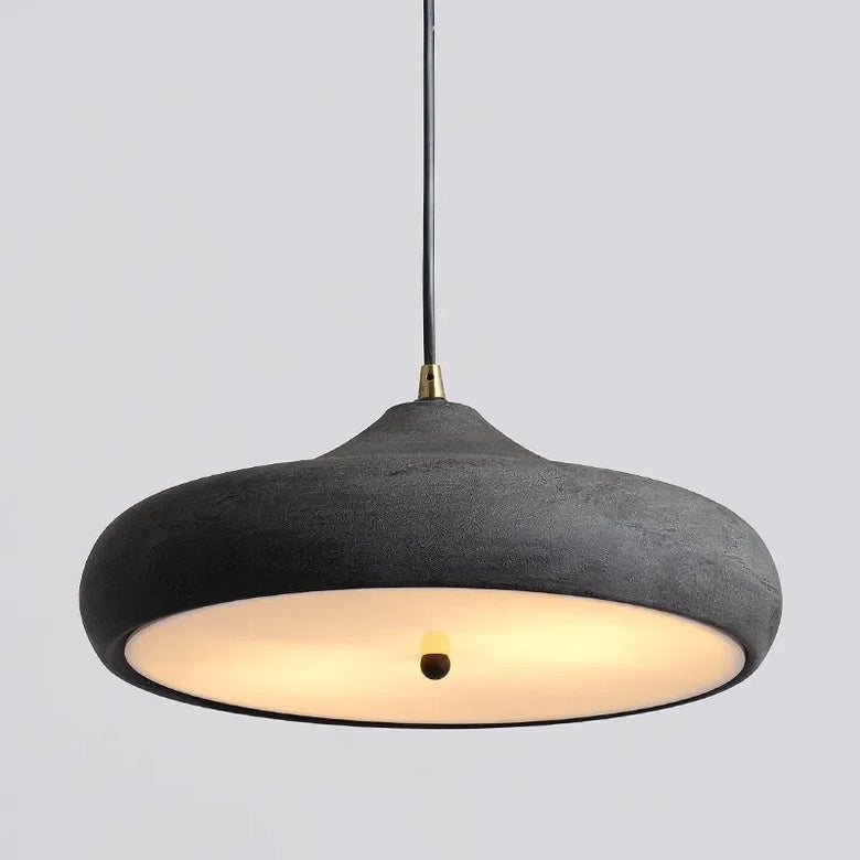 Hero Black pendant light with a warm glow on a gray background