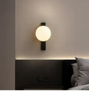 Minimalist Nordic Wall Lamp with Frosted White Ball illuminated on a modern bedroom wall.