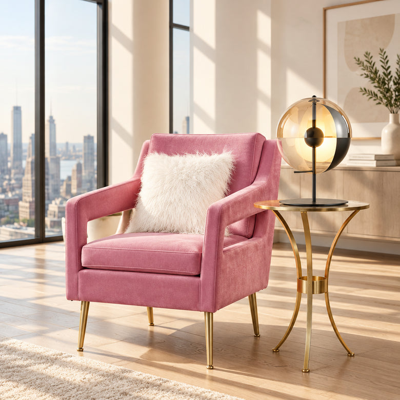 Pink armchair with a white pillow in a stylish room with a table and lamp.
