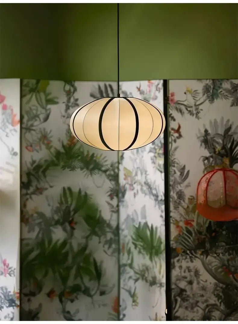 Zen Silk Pendant Light Mid Century Fabric Lantern hanging in a stylish room with botanical wallpaper.