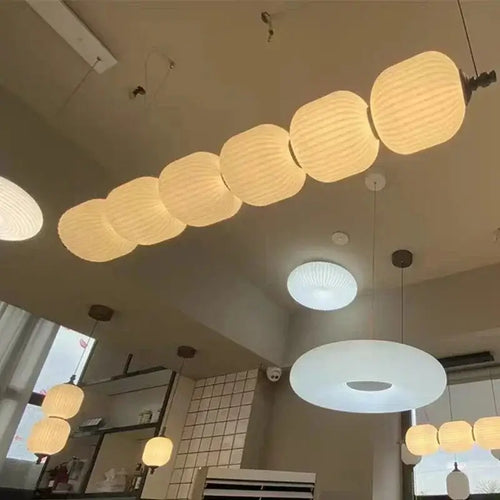 Nordic Art Deco Linear LED Pendant Light – Sculptural Acrylic & Iron Chandelier showcasing elegant acrylic shades in a modern setting.
