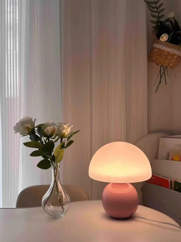 Mushroom LED USB Table Lamp in Pink – Soft Glow Bedside Lighting illuminating a cozy space with a vase of flowers.