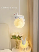 Childish and cozy decor featuring a moon lamp with a bunny design, creating a whimsical atmosphere.
