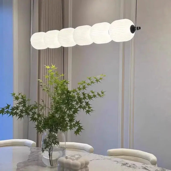 Modern Diffused Light Strip Pendant | Elegant Lighting Solution illuminating a dining table with green plants.