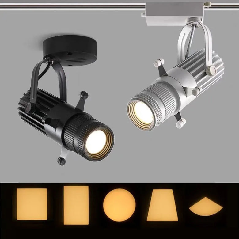 Two LED track spotlight lamps shown against a gray background, one black and one silver, with a row of illuminated light shapes below demonstrating color-changing functionality.