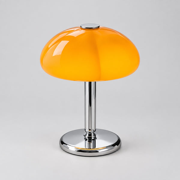 Hero Orange table lamp on a wooden surface with a cup and saucer, and a magazine in the background.