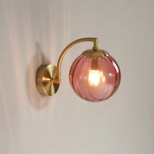 Colourful Glass Modern Wall Light with a pink bulb and golden metal base, perfect for adding elegance to any room.