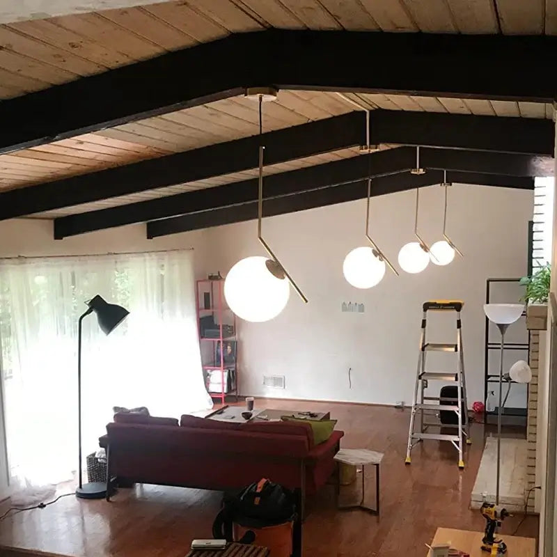 Danish Designer Pendant Light illuminating modern living room with elegant white lampshades and wooden beams.