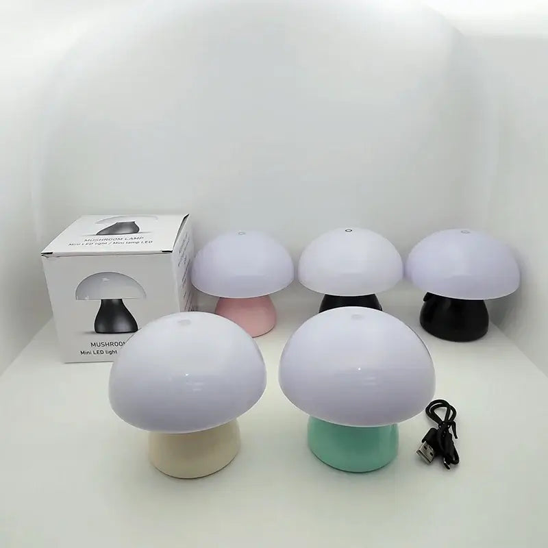 Mushroom-shaped lamps with different colored bases on a white surface, including a box in the background.