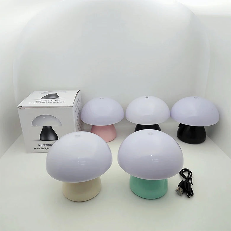 Mushroom-shaped lamps with different colored bases on a white surface, including a box in the background.