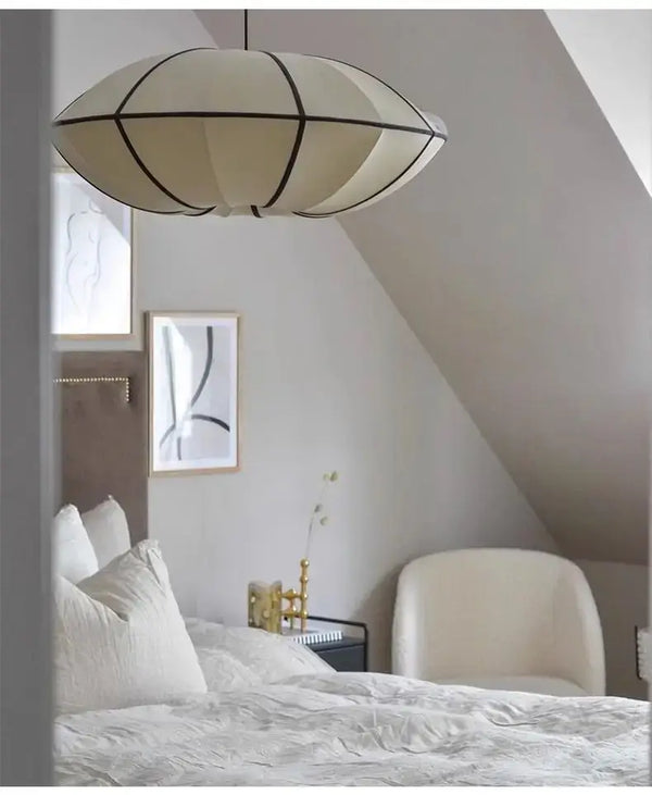 Zen Silk Pendant Light Mid Century Fabric Lantern illuminating a stylish bedroom with a warm glow.