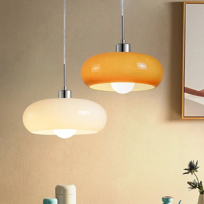 Hero - Two pendant lights hanging from a beige wall with a mirror and decorative items below.