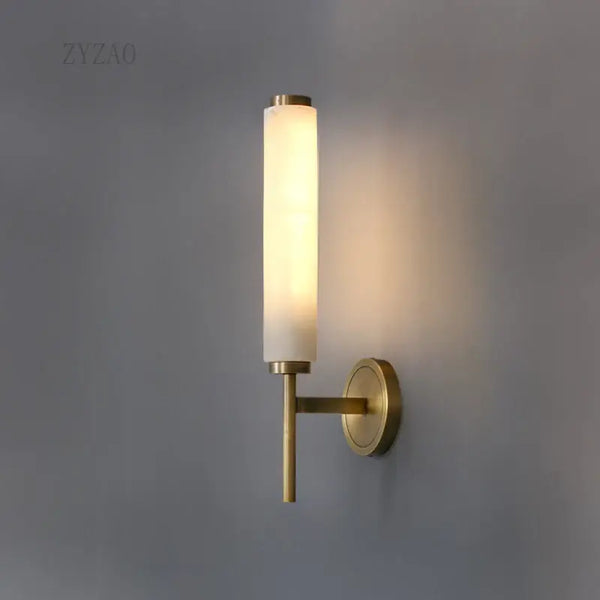 Stylish Art Deco Brass Wall Lamp illuminating a modern space with frosted glass and brass accents.