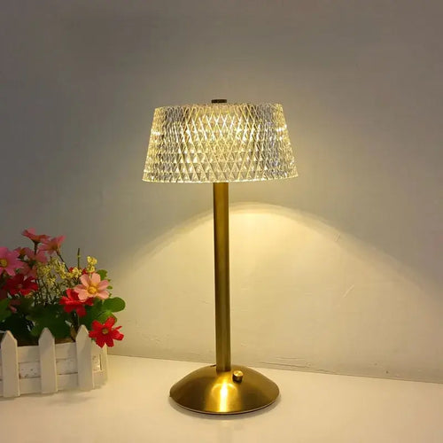 Hero Cordless table lamp with a crystal shade on a white surface next to flowers.