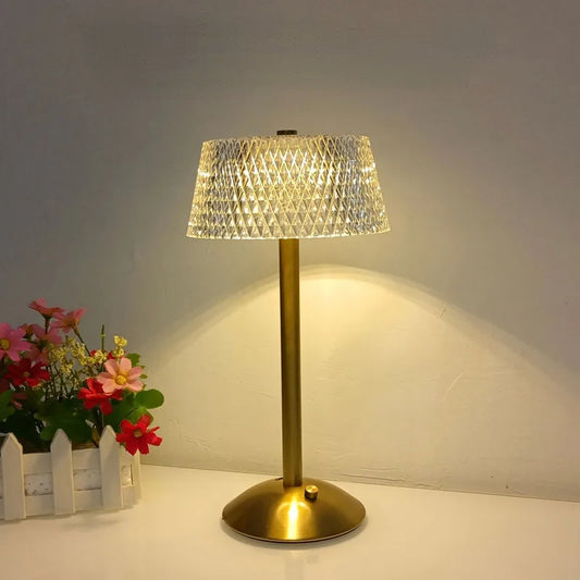 Hero Cordless table lamp with a crystal shade on a white surface next to flowers.